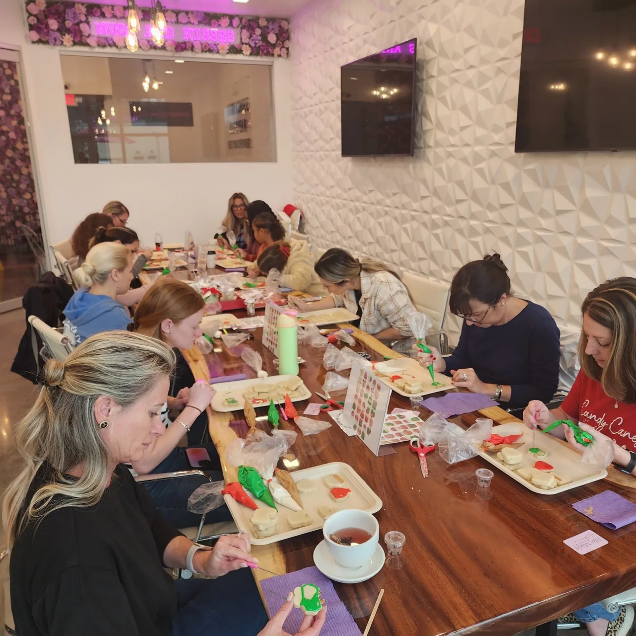 Guests decorating sugar cookies with royal icing at an Ellie Mae's Bakery cookie decorating class in Tampa