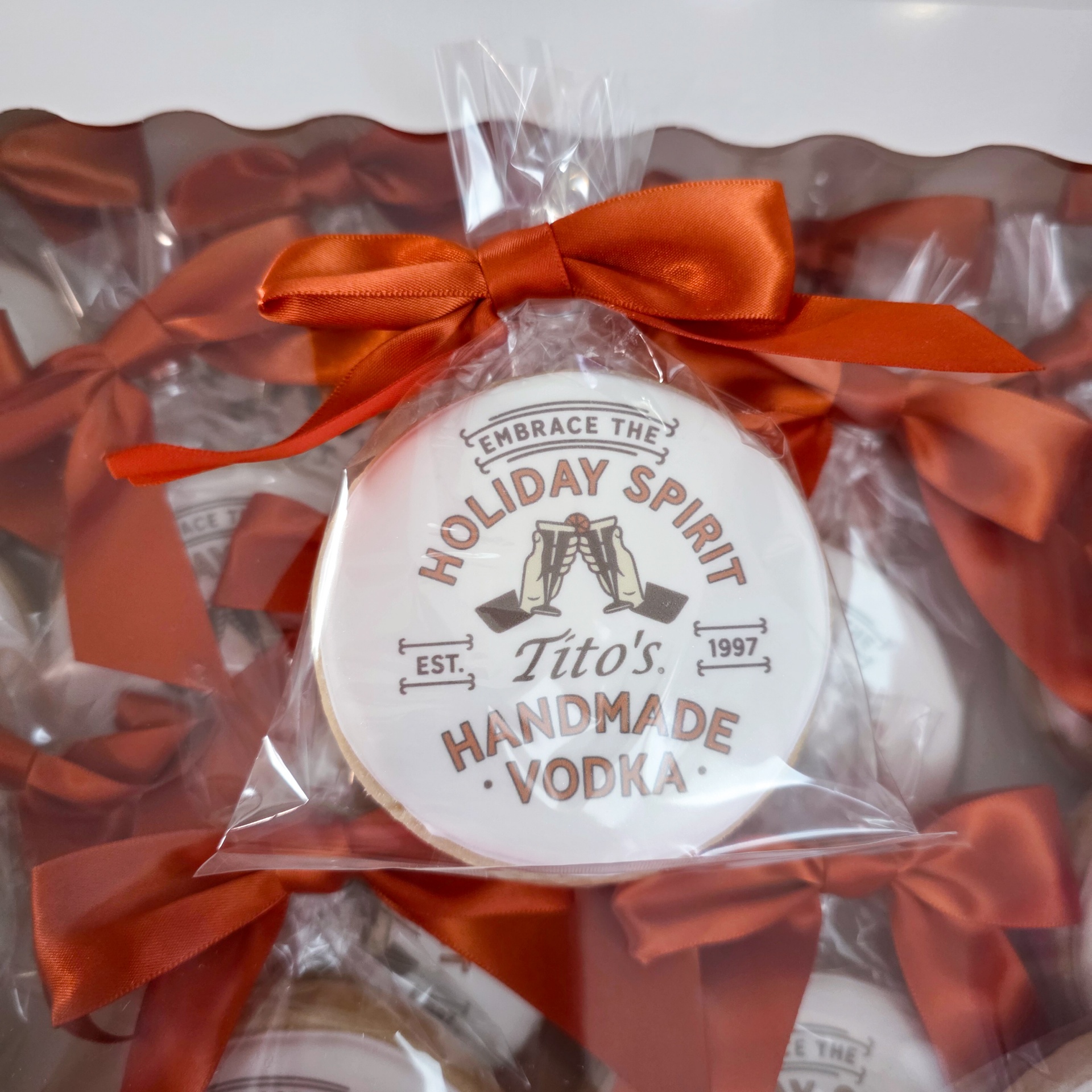 Tito's branded holiday cookie gifts wrapped with orange ribbon
