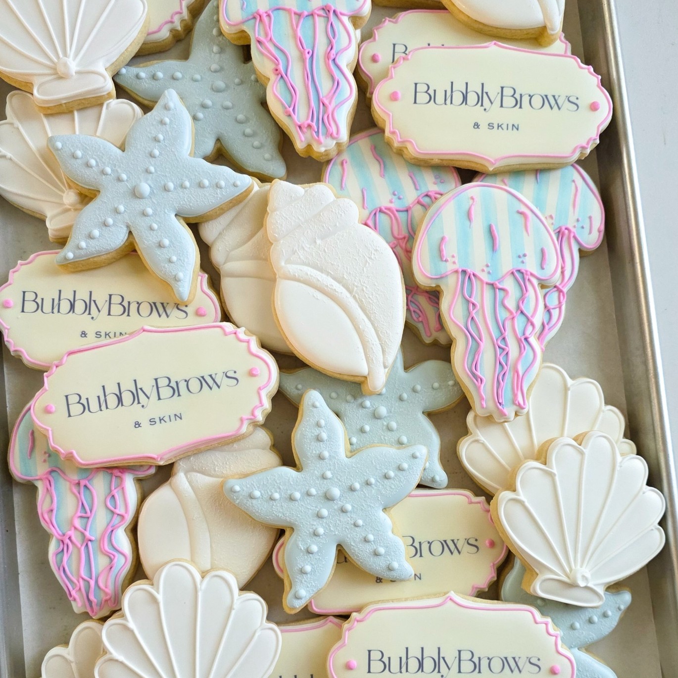 Hand-decorated custom sugar cookies with a branded logo cookie