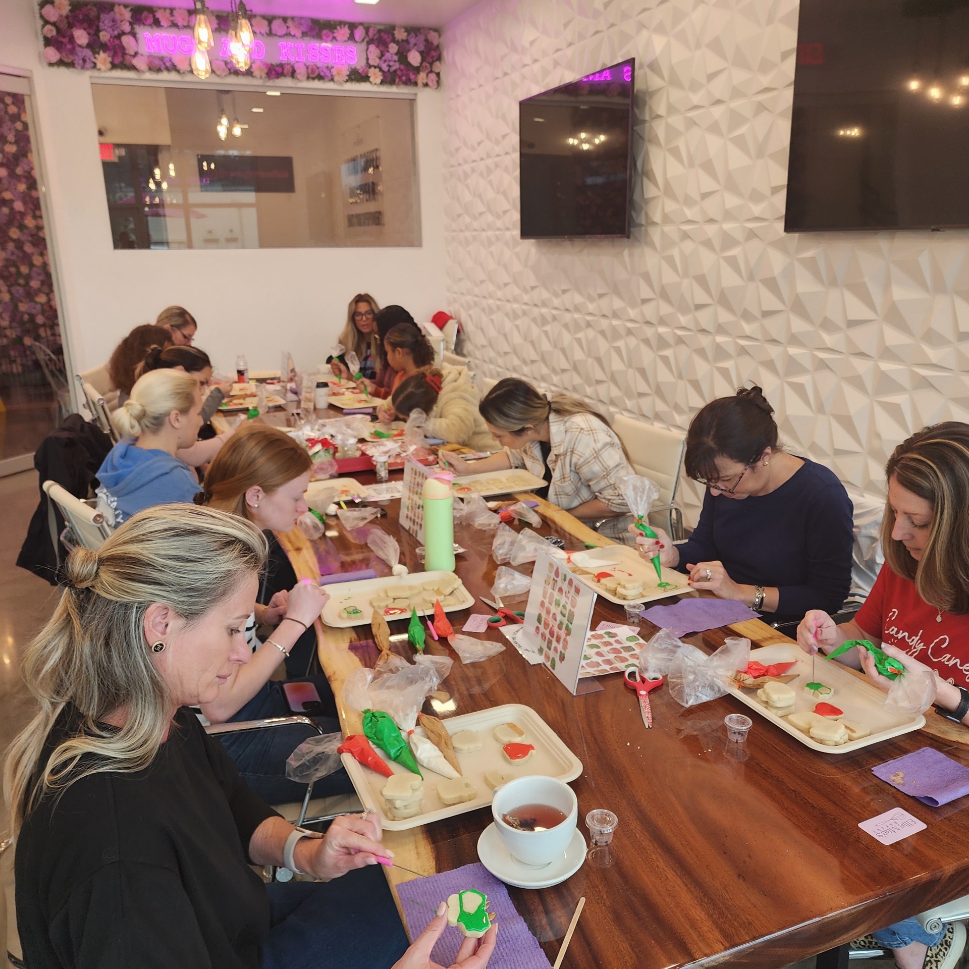 Guests actively decorating sugar cookies at an Ellie Mae's Bakery class