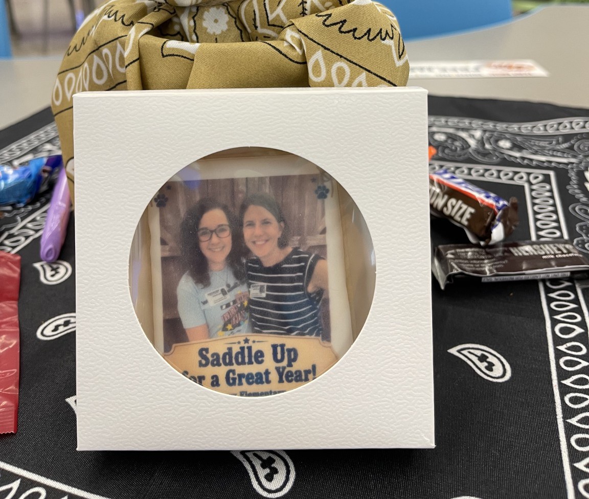 Finished personalized photo cookie inside an individual white window box at an event table