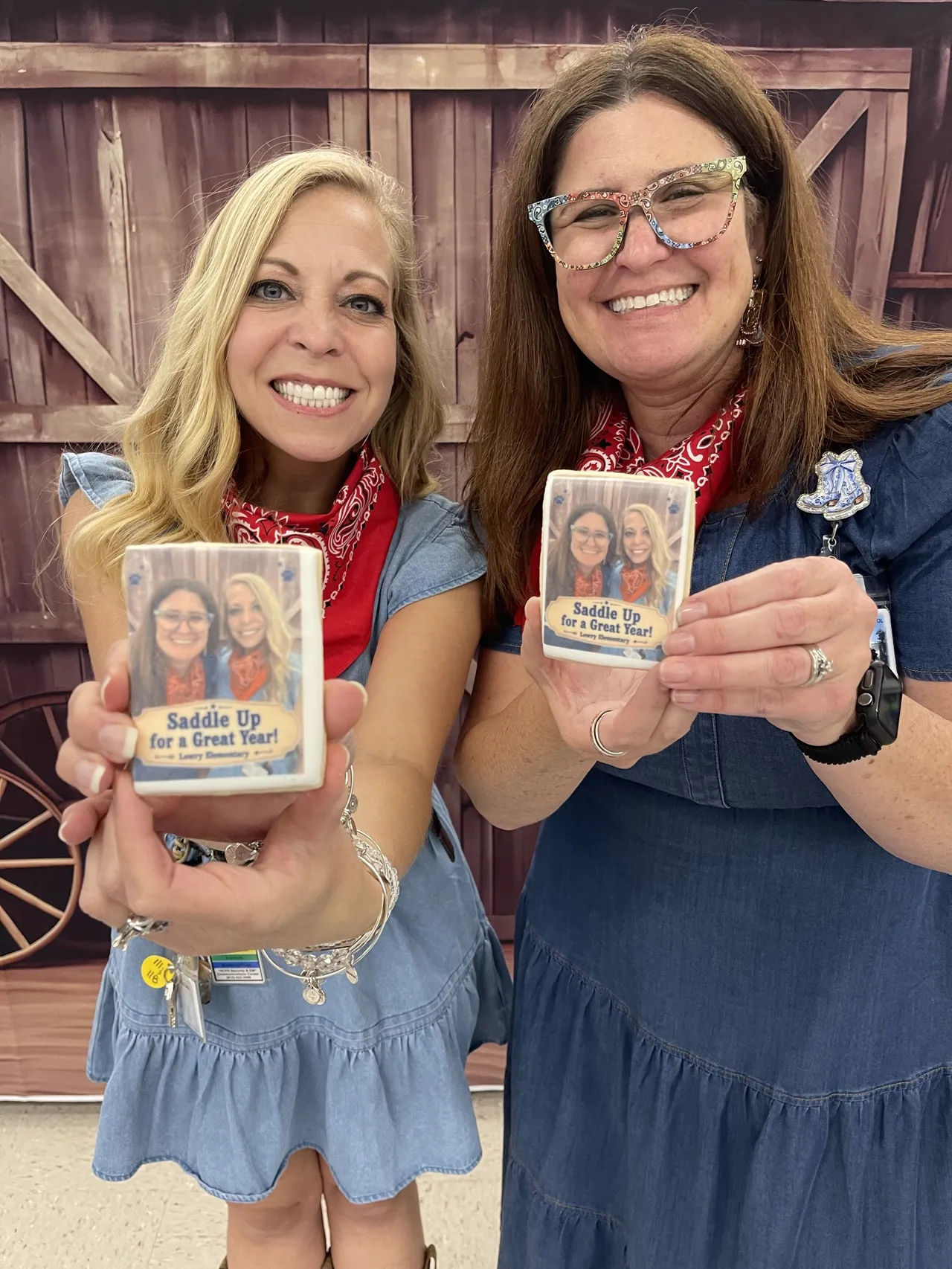 Two smiling guests holding personalized square photo cookies created at the Ellie Mae's Bakery Cookie Photo Booth